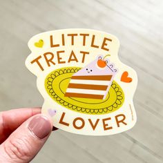 someone holding up a sticker that says, little treat lover on the front and back