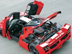 a red sports car with its hood open and the engine in position to be driven