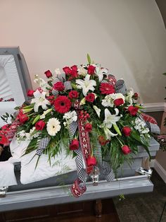 a bouquet of red and white flowers in a casket