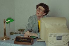 a man sitting at a desk in front of a computer