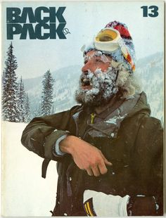 a man with a beard and goggles on his head is standing in the snow