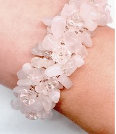 a close up of a person wearing a bracelet with flowers on it