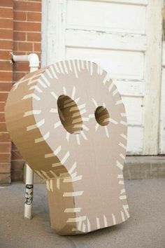 a cardboard sculpture made to look like an elephant with two holes in it's trunk