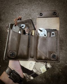 a person holding a leather wallet with two knives in it