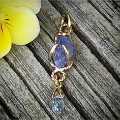 "Please go to my Instagram to watch the video about this pendant ~ A lovely genuine purple-blue color tanzanite glistens in a hollow 14k yellow gold wire bezel. Set with a light blue color sapphire bead is so fiery, vibrant and intense! A unique little piece with so much character. All handcrafted by me in my Michigan studio. Gem: approx. 12mm x 7mm / 2.15ct / genuine purple-blue tanzanite / with inclusions and imperfection surface 6mm x 3mm/ genuine light blue bead / with inclusions and imperfe Lavender Tanzanite Jewelry For Gifts, Unique Tanzanite Jewelry Gift, Unique Tanzanite Jewelry For Gifts, Handmade Tanzanite Yellow Gold Jewelry, Necklace Sapphire, Boulder Opal Ring, Halo Necklace, 14k Yellow Gold Necklace, Yellow Gold Necklace