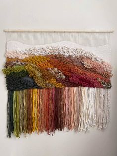 a wall hanging with many different colors of yarn