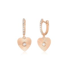 The Gold & Diamond Fluted Heart Drop Huggie Earrings add even more shine to our best-selling Diamond Huggie. With a heart-shaped drop featuring a central diamond set inside a gold sparkle design with fluted lines that beautifully reflect light, this huggie delivers dimension and depth to any look. Luxury Rose Gold Heart Earrings, Diamond Heart Drop Earrings Fine Jewelry, Elegant Heart Charm Huggie Earrings, Rose Gold Diamond Heart Cut Earrings, Rose Gold Heart Cut Diamond Earrings, Elegant Huggie Heart Earrings, Rose Gold Heart Pendant Earrings For Anniversary, Fine Jewelry Double Heart Earrings With Diamond Accents, Fine Jewelry Heart Earrings With Diamond Cut