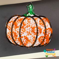 an orange and white painted pumpkin on a gray background