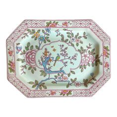 an ornately decorated porcelain dish with flowers and birds on the rim, painted in pink