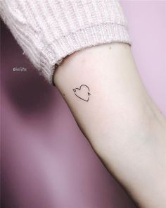 a small heart tattoo on the left inner arm, with an arrow in the middle