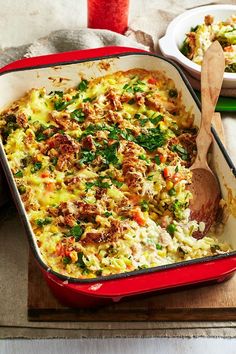 a red casserole dish filled with vegetables and meat