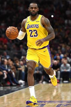 a basketball player dribbling the ball in front of an audience at a game