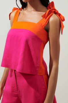 a woman wearing an orange and pink top