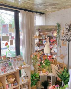 a room filled with lots of different types of flowers and plants next to a window