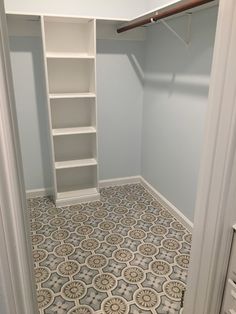 an empty walk - in closet with shelves and tile flooring on the walls, along with drawers