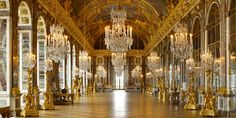 an ornate hall with chandeliers and mirrors