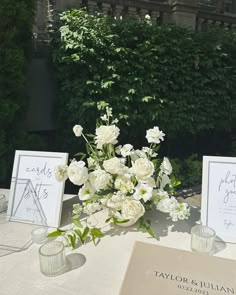 the table is set with white flowers and place cards