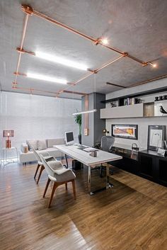 an office with wooden floors and white furniture in the center is lit by recessed lights