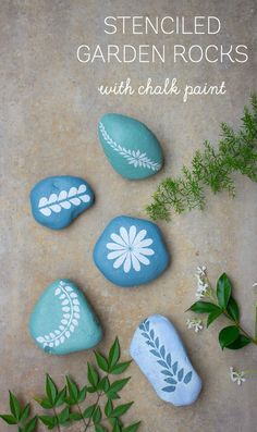 painted rocks with chalk paint and stenciled flowers on them are the perfect way to decorate your garden