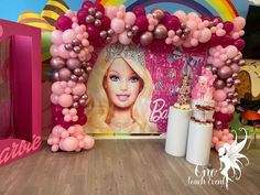 there is a barbie birthday party with balloons on the wall and decorations in front of it