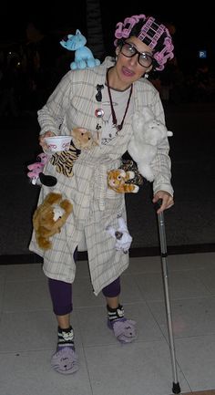 a woman dressed in costume with stuffed animals on crutches and holding a cane