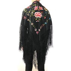 DETAILS A small, vintage traditional Flamenco dancer's black shawl or mantoncillo pico with a floral embroidery design and long fringe.  COLOR(S) Multi-color on black ground  PLACE OF ORIGIN Spain | Europe  DATE 20th century  DIMENSIONS Width 63 Depth 63 inches Without fringe: Width 36 Depth 36 inches Traditional Embroidered Shawl For Spring, Bohemian Shawl With Floral Embroidery, Folk Style Black Shawl For Winter, Black Bohemian Shawl For Spring, Black Shawl With Intricate Embroidery In Traditional Drape, Spring Shawl With Tassels, Traditional Spring Shawl, Black Embroidered Shawl With Traditional Drape, Traditional Black Embroidered Shawl