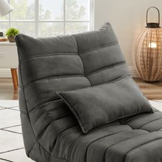 a gray futon chair sitting on top of a white rug