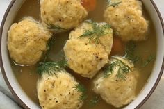 a bowl filled with dumplings and carrots on top of a table