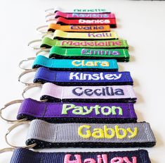 a row of lanyards with the names of different colors and font on them