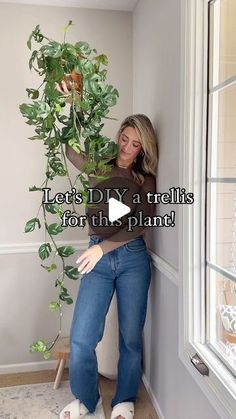 a woman leaning against a wall holding a potted plant with the words let's diy a trellis for the plant