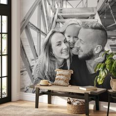 a couple is posing in front of a large photo on the wall next to a bench