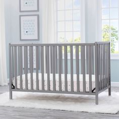 a baby crib in a room with blue walls and white rugs on the floor