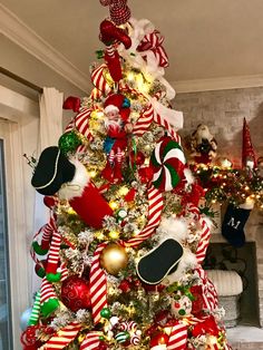 a christmas tree decorated with candy canes, stockings and other holiday decorations is shown