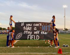 cheerleaders holding up a sign that says if you can't take a hit stay off the field