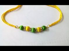 yellow and green beaded bracelet with beads on the end, sitting on a white surface