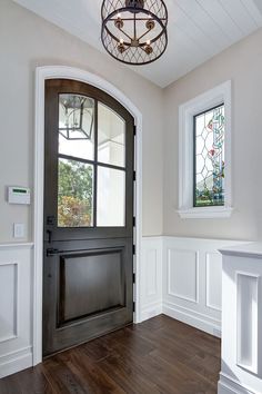 an empty entryway with wood flooring and stained glass windows