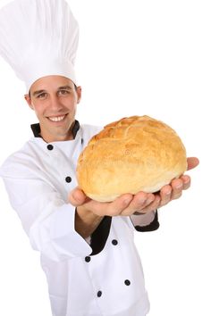 a chef holding a loaf of bread in his hands