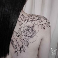 the back of a woman's shoulder with flowers on it