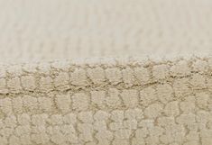 a close up view of the textured fabric on a bed