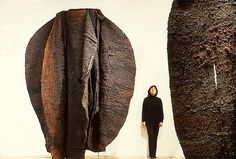 a person standing in front of two large sculptures