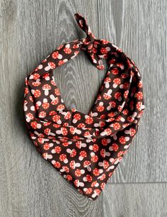 a red and white flowered bandana on a wooden floor with grey wood planks