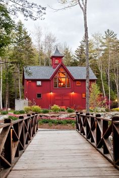 a red barn with a wooden bridge leading to it