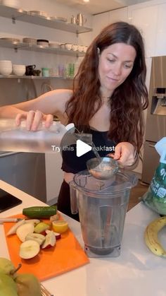 a woman is mixing something in a blender