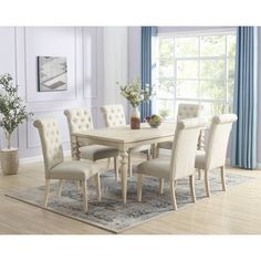 a dining room table and chairs in front of a window