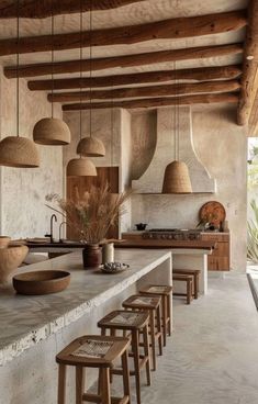 a kitchen with several stools and lights hanging from the ceiling