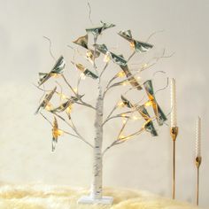 a small tree with birds on it and some lights in the shape of branches that are lit up