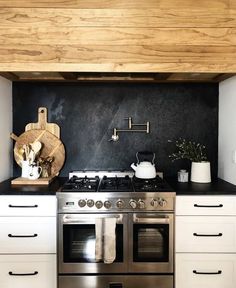 a stove top oven sitting inside of a kitchen next to white cabinets and counter tops