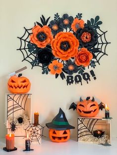 an assortment of halloween decorations on a white surface with candles and pumpkins in the background