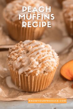 peach muffins with white frosting on top and sliced peaches in the background