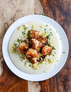 a white bowl filled with food on top of a wooden table